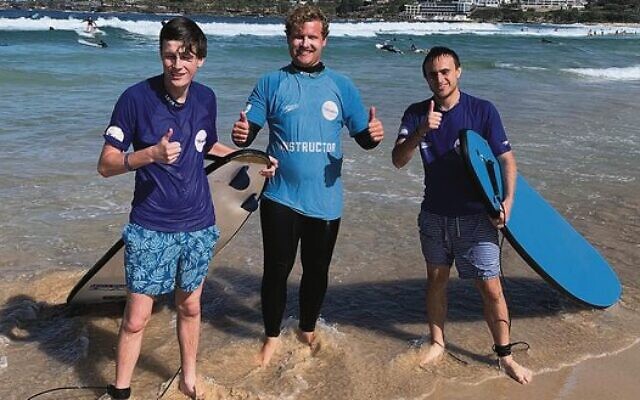 Maccabi NSW All Abilities Surf's Up participants Will Gibbons (left) and Jarred Morris (right) with their instructor at Bondi Beach on May 1.