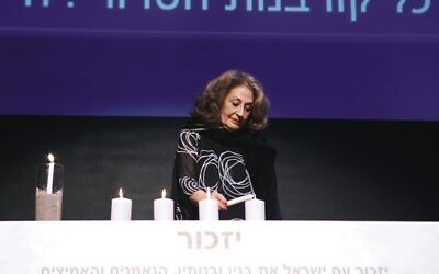 Hilary Friedland lights a candle for Eliyahu David Kay. Photo: Peter Haskin