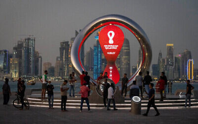 People gather around the official countdown clock showing remaining time until the kick-off of the World Cup 2022, in Doha, Qatar. Photo: AP Photo/Darko Bandic, File