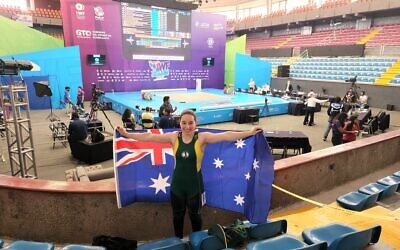 Layla Bloom, 16, proudly holding the Australian flag at the 2022 Weightlifting World Youth Championships earlier this month in Mexico.