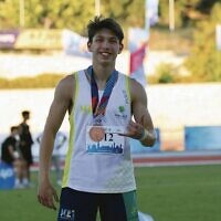 Zac Urbach celebrates his athletics bronze medal in the junior 200m.