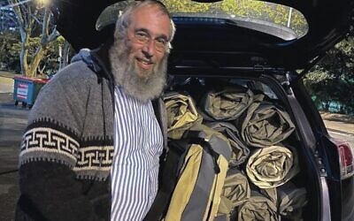 Rabbi Mendel Kastel with a boot load of Shelterbags.