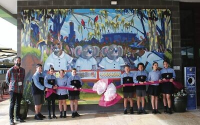 Artist in residence Glen Downey with year 6 students in front of the new mural.