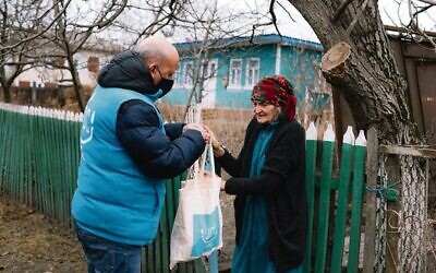 A JDC client in Ukraine receiving her weekly food and medication package.
