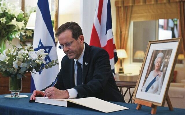 President Isaac Herzog signs a condolence book for Queen Elizabeth II at the British ambassador's residence in Tel Aviv. Photo: Kobi Gideon/GPO