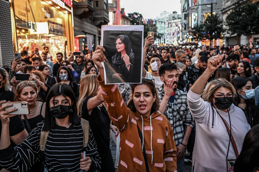 A protester holds a portrait of Mahsa Amini  during a demonstration on September 20, 2022. Photo: Ozan Kose/AFP
