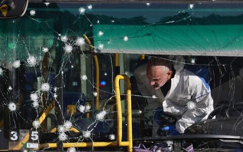 An Israeli forensic expert works at scene of an explosion in Jerusalem at a bus stop. Photo: Menahem Kahana/AFP