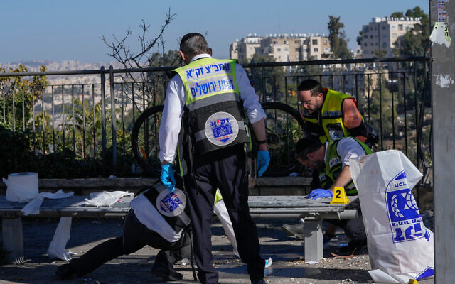 Members of Zaka Rescue and Recovery team clean blood from the scene of an explosion at a bus stop in Jerusalem, Wednesday, Nov. 23, 2022. Photo: AP Photo/Maya Alleruzzo