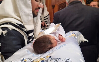 Rabbi Yisrael Blassberger holding the baby about to be named Aharon Chaim.