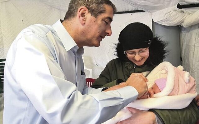 Professor Yitshak Kreiss with a baby at Israel's field hospital in Ukraine.