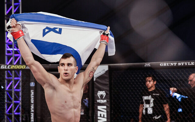 Natan Levy proudly shows an Israeli flag before his matches. Photo: Amy Kaplan