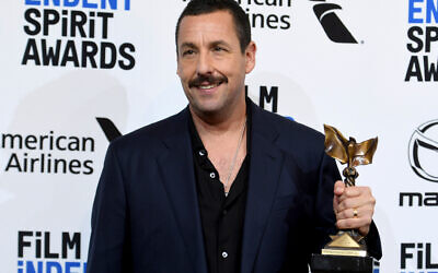 Adam Sandler poses in the press room with the award for best male lead for Uncut Gems at the 35th Film Independent Spirit Awards. Photo:  Richard Shotwell/Invision/AP via Times of Israel