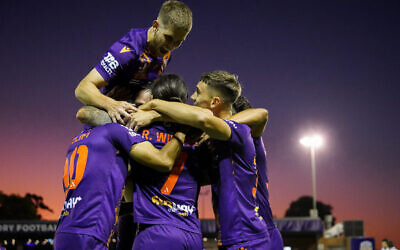Jacob Muir atop a Perth Glory team huddle after their win last week against reigning premiers Western United. Photo: Estybsphoto