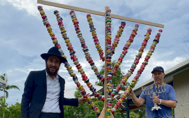 Rabbi Ari Rubin and Aaron Standley next to the menorah constructed out of recycled cans for the public lighting in Cairns on December 18. Photo: Ari Rubin