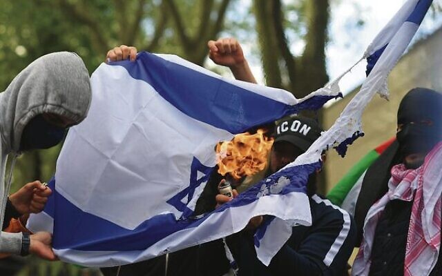 Illustrative: Pro-Palestinian activists burn an Israeli flag outside the Israeli embassy in central London on May 22, 2021. Photo: Justin Tallis/AFP