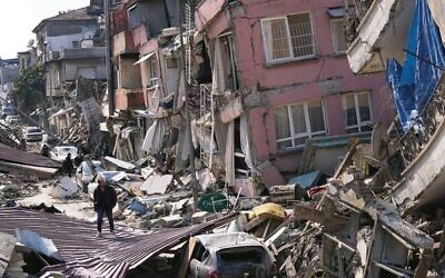 A man walks over debris of collapsed buildings in Hatay, Turkey. 
Photo: Hussein Malla/AP