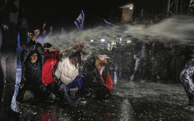 Police use water cannons to disperse protesters outside Prime Minister Benjamin Netanyahu's residence in Jerusalem on March 26. Photo: Noam Revkin Fenton/Flash90