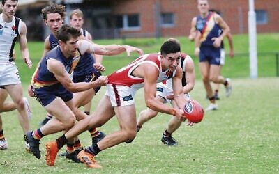 Jackas' Charles Hamilton handballs while being tackled in round one last Saturday versus St Bedes. Photos: Peter Haskin
