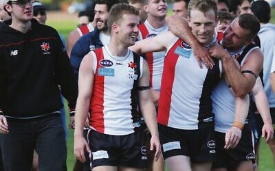 Jackas senior reserves player Jordan Bade-Kennett, centre, is embraced by teammates after last Sunday's win. Photo: Peter Haskin
