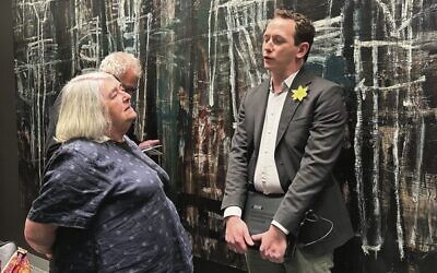 Michal Majewski (right), wearing a paper daffodil memorialising Shoah victims, gives genealogy advice at the Melbourne Holocaust Museum. 
Photo: Peter Kohn