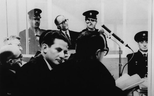 Adolf Eichmann listens to the proceedings during his trial through a glass booth. Photo: USHMM.
