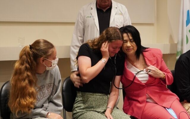 Keren Dee listens to her mother, Lucy Dee's heart, beating in Tali Valencia who received a donor transplant after Lucy was killed in a terror attack. Credit: Jotam Confino