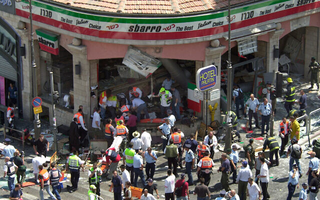 Police and medics surround the scene of a suicide bombing inside Jerusalem's Sbarro restaurant, Thursday, August 9, 2001. Fifteen people were killed, and 130 injured. Photo: AP/Peter Dejong