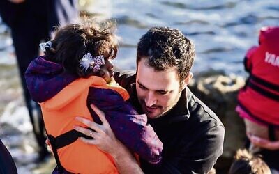 Yotam Polizer aids a Syrian refugee in Lesbos, Greece, in 2015. Photo: IsraAID