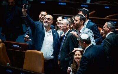 Coalition lawmakers crowd around Justice Minister Yariv Levin to take a celebratory selfie in the Knesset, as they pass the first of the coalition's judicial overhaul laws, July 24, 2023. Photo: Yonatan Sindel/Flash90