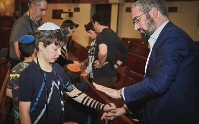 Louis Super (left) lays Tefillin with Rabbi Yaakov Glasman. Photo: Paul Topol.