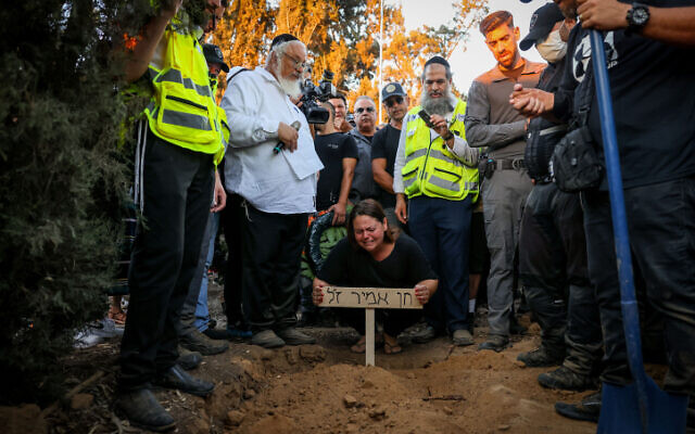 Vered Assayag Amir and other mourners attend the funeral of her husband Chen Amir, a municipal patrolman who was shot dead in a terror attack in Tel Aviv a day earlier, at Kibbutz Reim, August 6, 2023. Photo: Chaim Goldberg/Flash90