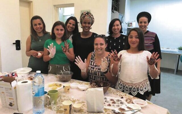 Shayna (fifth from left) volunteers with children in the youth villages, a UIA project supported through Australian donations.