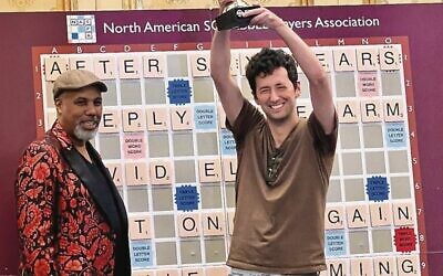 David Eldar raises the 2023 world Scrabble championship trophy. Photo: NASPA