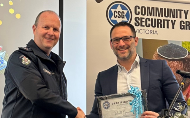 Victoria Police Assistant Commissioner Southern Metro, Russell Barrett, receives a certificate of appreciation from CSG CEO Justin Kagan
