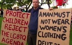 Stephen Wells with anti-LGBTQI+ placards.