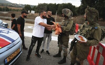 Druze residents hand out food to Israeli soldiers near the Lebanon border. Photo: David Cohen/Flash90