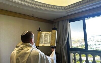 A member of Communications Minister Shlomo Karhi's delegation holds up a Torah scroll during a morning prayer service in Riyadh, Saudi Arabia. Photo: Communications Ministry
