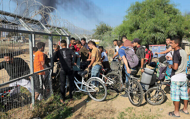 Palestinians from the Gaza Strip enter Kibbutz Kfar Aza on Oct. 7, 2023, amid a massive assault by the Hamas terror group. (The Times of Israel: AP Photo/Hassan Eslaiah)