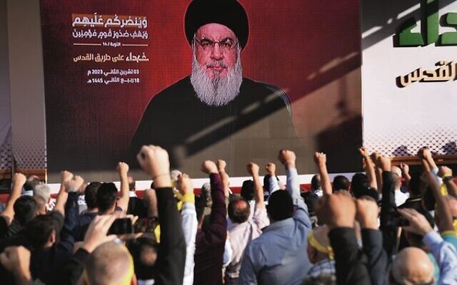 Hezbollah supporters raise their fists and cheer as leader Hassan Nasrallah gives a speech via a video link on Friday, November 3. 
Photo: AP Photo/Hussein Malla