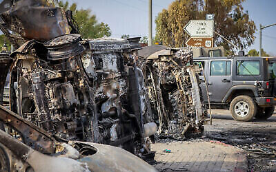 Israeli security seen next to burnt cars at the entrance to Kibbutz Be’eri, near the Israeli-Gaza Border, in southern Israel, Oct. 9, 2023. (AJNUK: Yossi Zamir/Flash90) רחבות ברזל