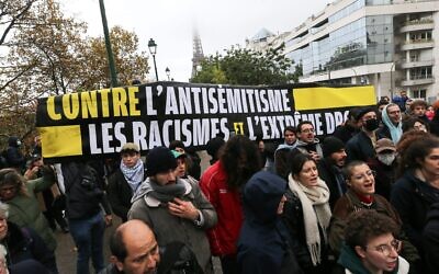 Demonstrators carry a banner reading "Against antisemitism, racism and the extreme right" during a rally at the Square des Martyrs Juifs in Paris, Nov. 12, 2023. (The Times of Israel: Michel Stoupak/NurPhoto via Getty Images)
