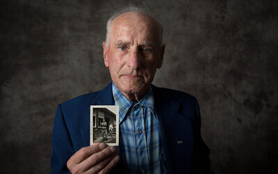 Jack Meister holding a photo of himself, taken at the liberation of Buchenwald in April 1945. Photo: Sydney Jewish Museum