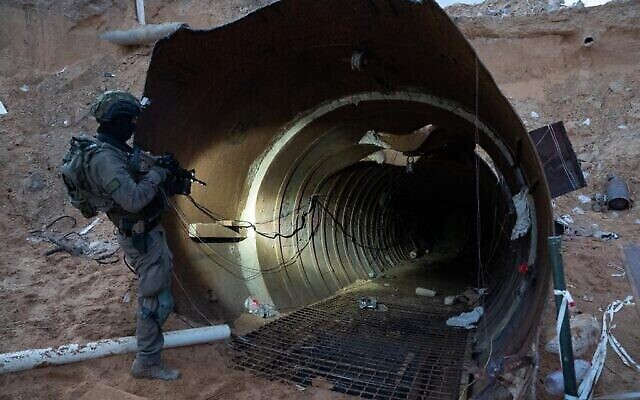 A soldier stands at the entrance to a large Hamas tunnel found near the Erez border crossing in the northern Gaza Strip, in a handout image published December 17, 2023. (The Times of Israel: Israel Defense Forces)