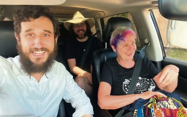 Rabbi Ari Rubin (left) giving a lift to flood-impacted Cairns residents Myra Gold (right) and Owen Taylor-Ray, on Tuesday.