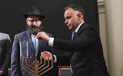 Opposition leader John Pesutto lights the menorah under the watchful gaze of Rabbi Chaim Herzog. Photo: Peter Haskin