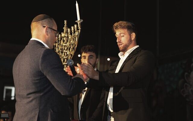 From left: Rabbi Gad Krebs, Ofir Tamir, and Amit Parpara light a candle at the Lights of Hope event. Photo: Vicki Lauren Photography