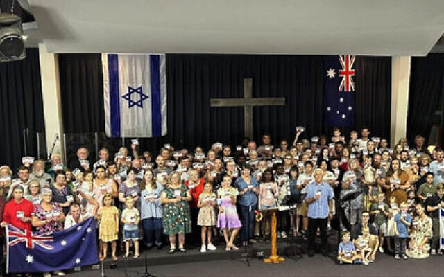 The Manning Valley Covenant Ministries congregation holding an Israeli flag and small posters of Israeli hostages, in early December.