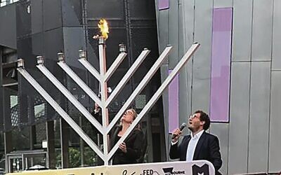 Premier Jacinta Allan lights the menorah at Pillars of Light as Rabbi Gabi Kaltmann recites the brachot.