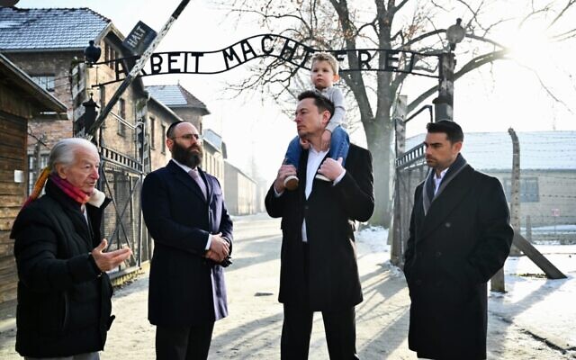 Holocaust survivor Gidon Lev, European Jewish Association Chairman Rabbi Menachem Margolin, Elon Musk with son, and Ben Shapiro stand together at the entrance of Auschwitz, Jan. 22, 2024. (JTA: Courtesy EJA)