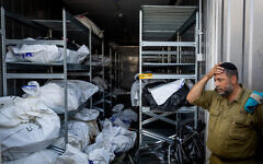 A military official at the forensic center at the Military Rabbinate's headquarters in Ramle stands in front of the remains of victims of Hamas's October 7 onslaught in Israel, October 13, 2023. (The Times of Israel: Nati Shohat/Flash90)